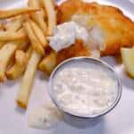 Tartar Sauce with fries and beer battered fish in background on plate