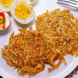 Panini Press Hash Browns on white plate with hard boiled eggs