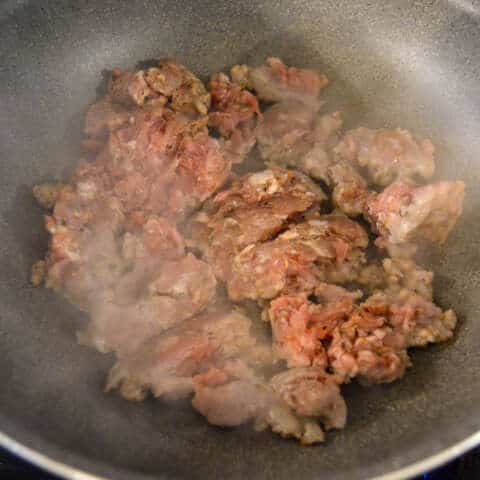 Adding raw Italian Sausage to medium high heat skillet to cook