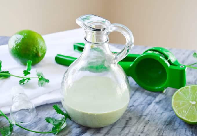Cilantro Lime Ranch Dressing with citrus squeezer and limes