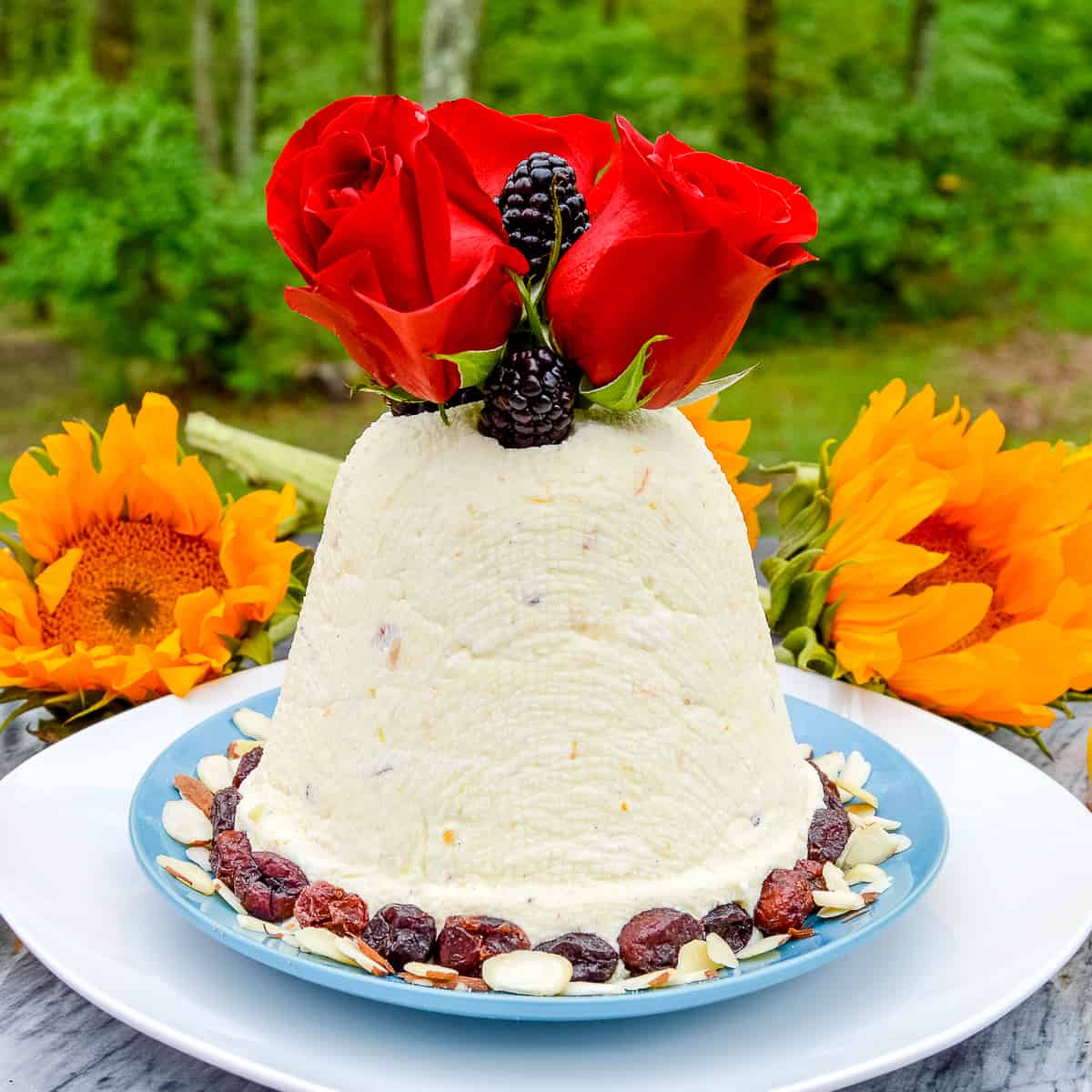 Paskha (Russian/Ukrainian) Crustless Cheesecake with roses and blackberries on top, sunflowers in the background