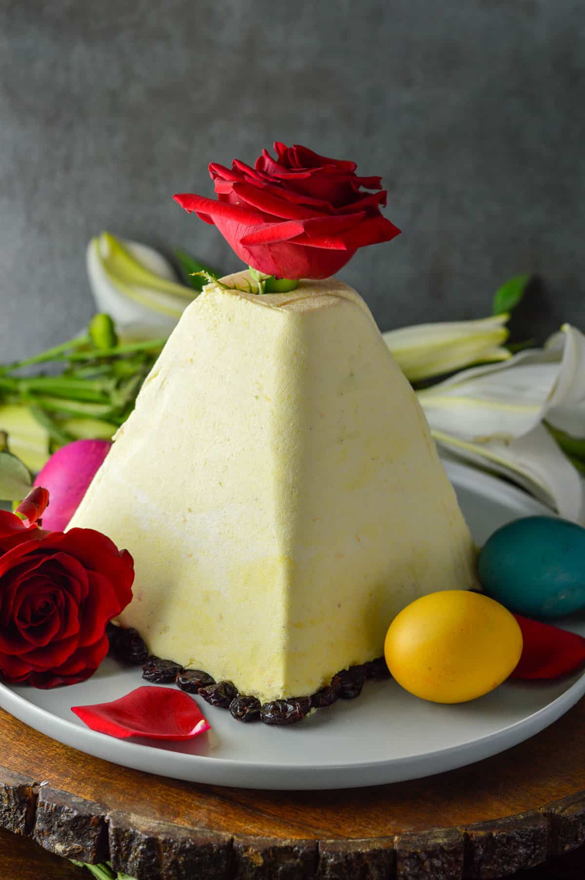 Russian Paskha cheesecake on white platter with eggs and flowers