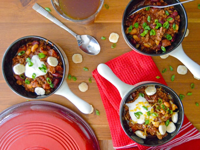 Chili with sour cream, oyster crackers and green onion in bowls