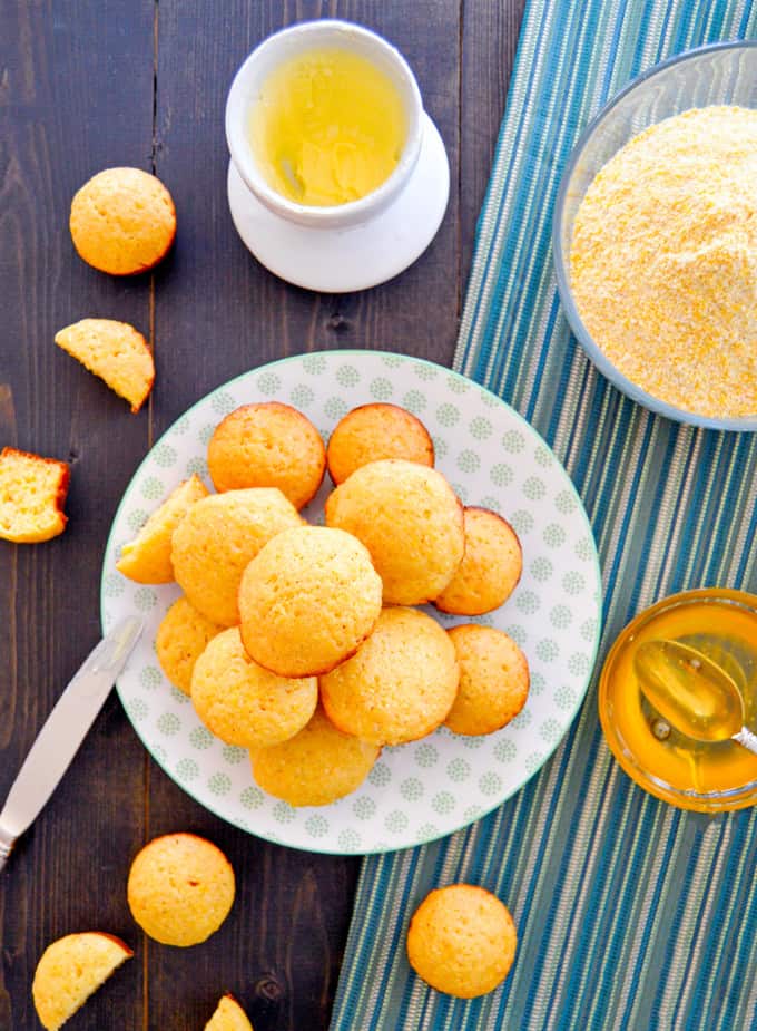 Mini Honey Cornbread Muffins up top view with cornmeal, butter and honey