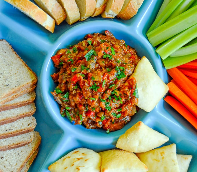 Roasted Red Pepper & Eggplant Spread close up with toasts, pita chips, carrots and celery