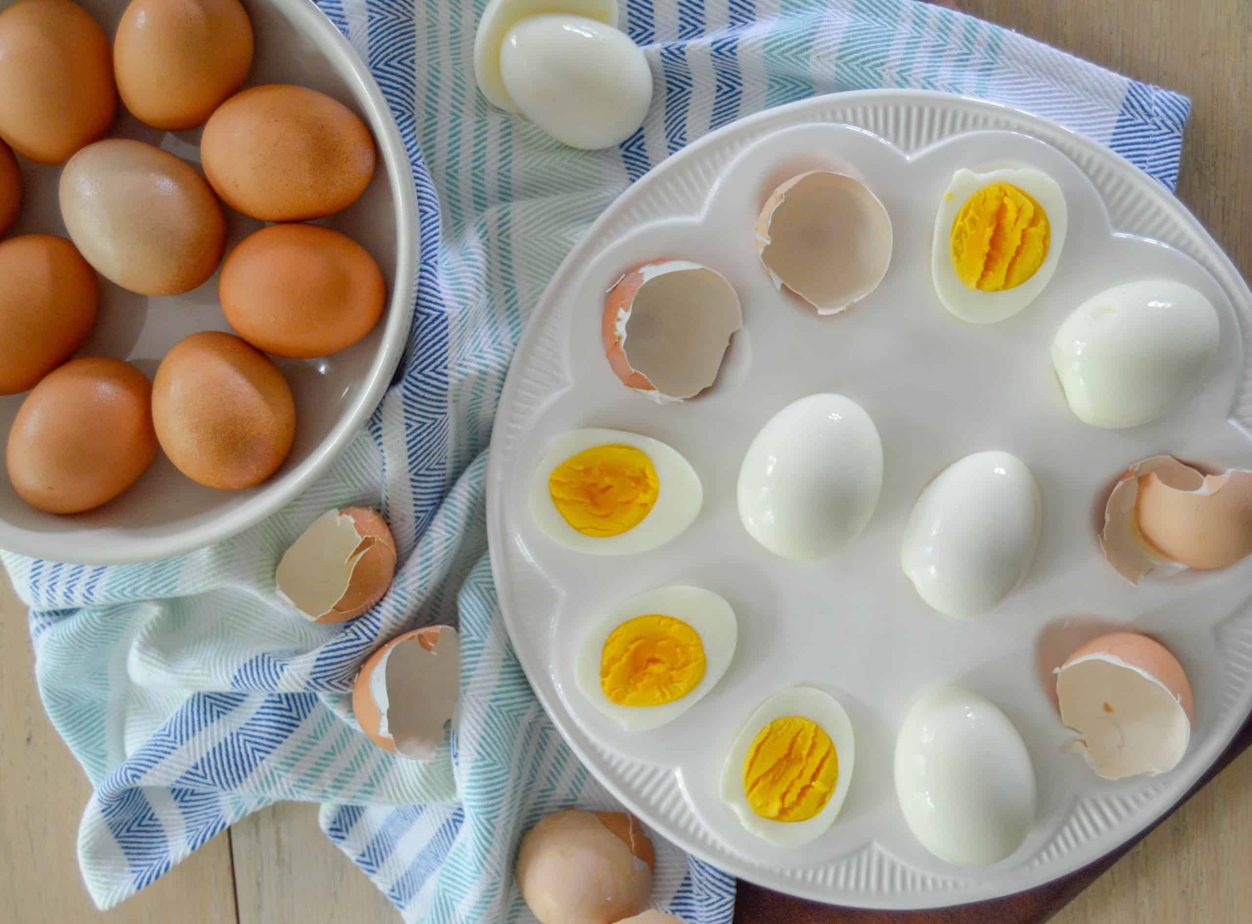 Easy peel Hard boiled eggs half peeled next to shells with hard boiled eggs in bowl