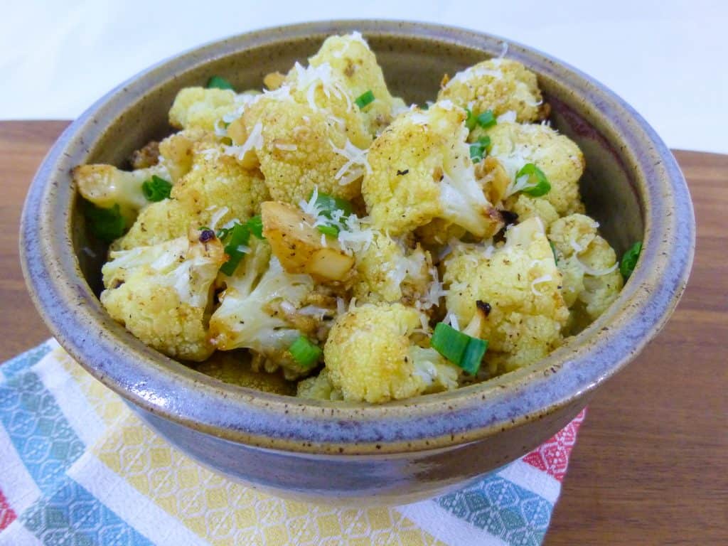 Cauliflower with lemon, garlic, green onion in serving bowl