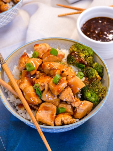 Up close Chicken Teriyaki Bowl with green onion and sauce and chop sticks