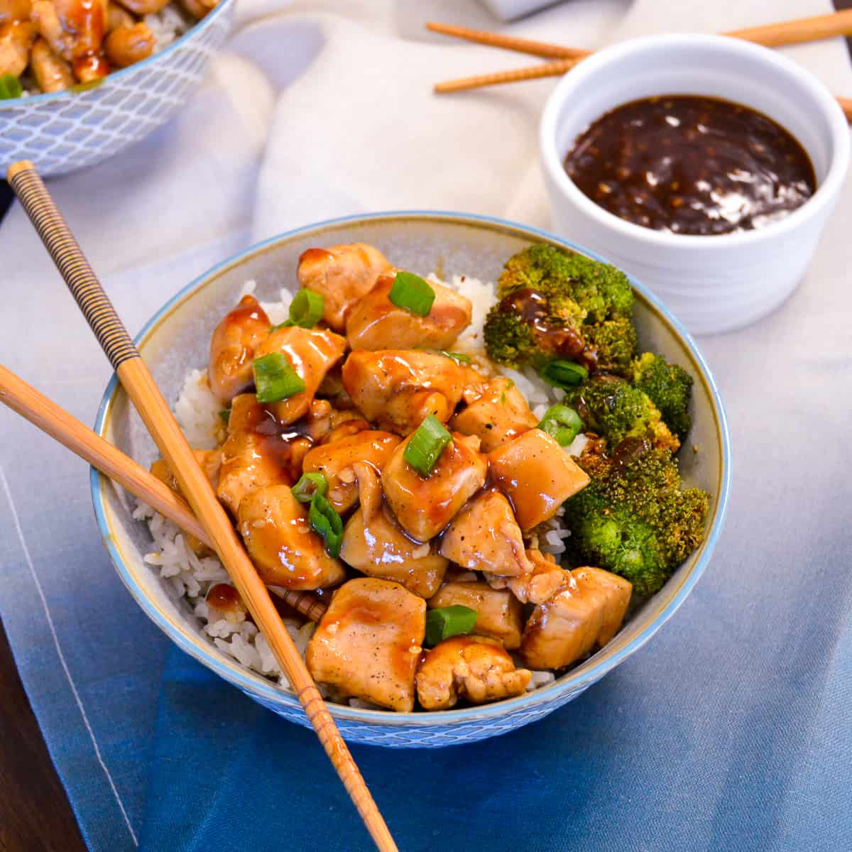 Up close Chicken Teriyaki Bowl with green onion and sauce and chop sticks