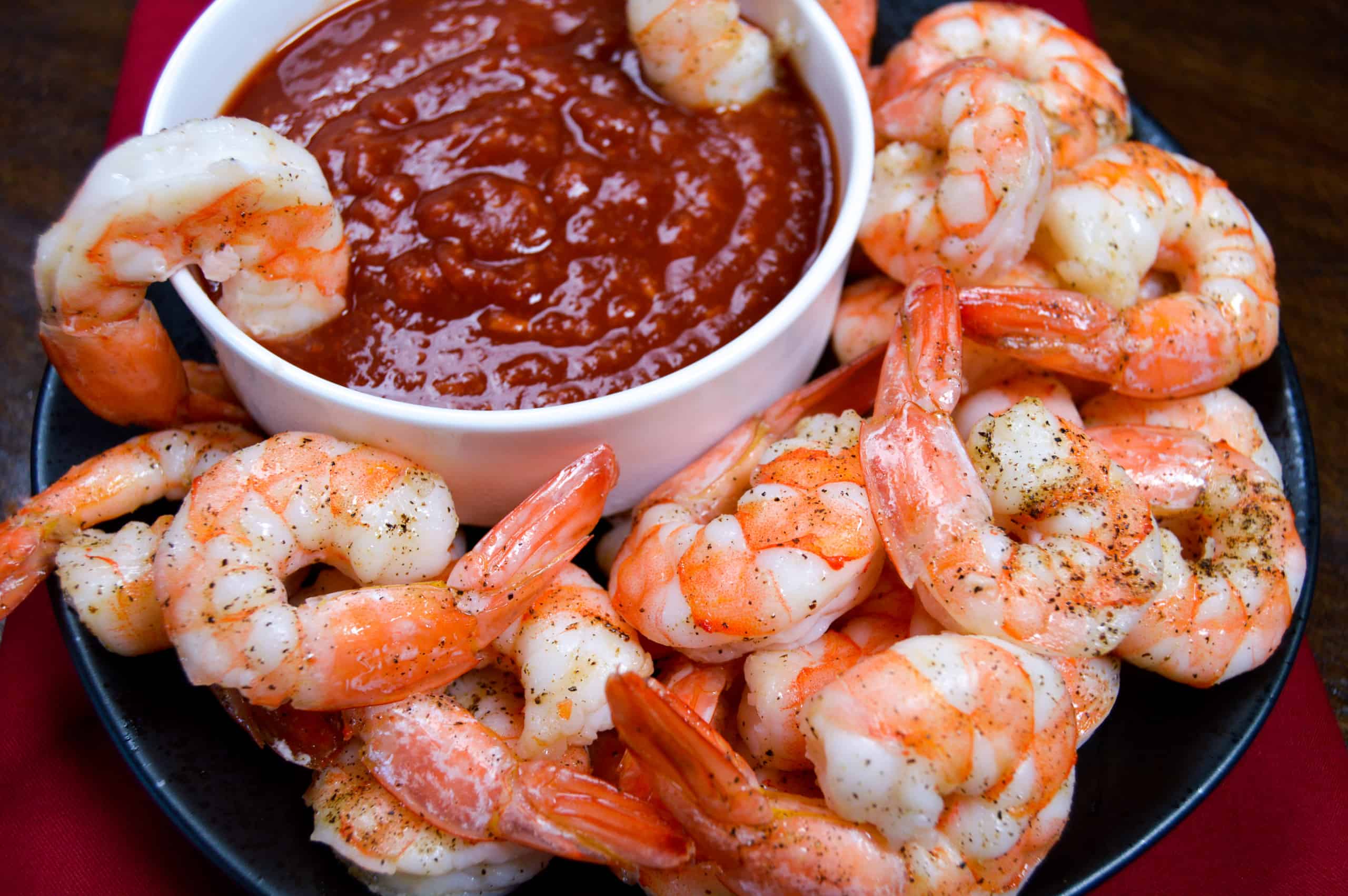 Big plate of roasted shrimp and cocktail sauce of shrimp cocktail