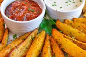 Air Fryer Potato Wedges on plate with 2 ramekins with ketchup and ranch dip
