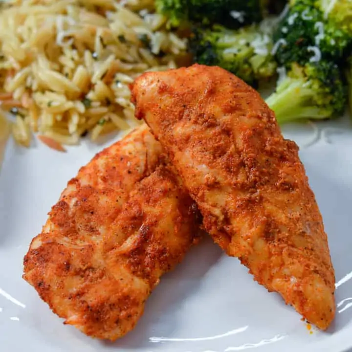 No Breading Air Fryer Chicken Tenders on white plate with orzo and cooked broccoli in background