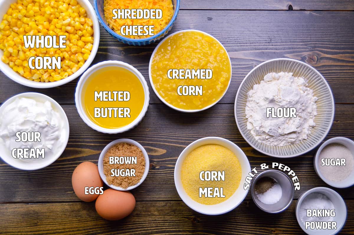 Corn Pudding Casserole Ingredients in bowls and ramekins on wooden cutting board