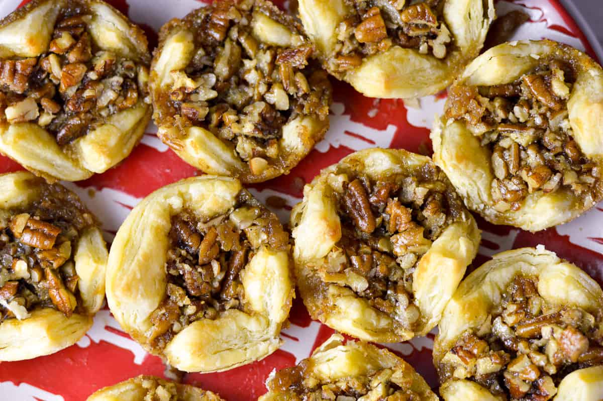 Close up, over top shot of pecan pie puffs on red and white Christmas dish 