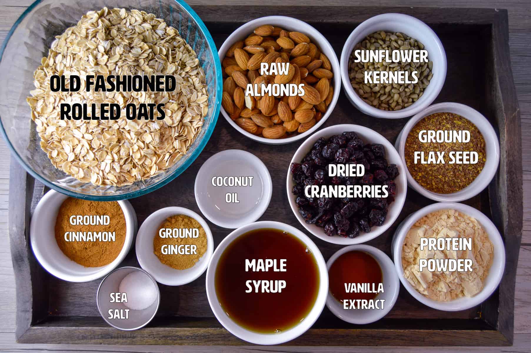 Ingredients for granola shown on a wooden serving tray 