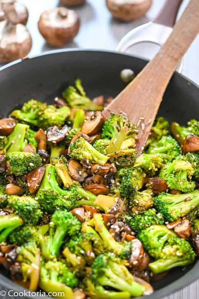 Broccoli Mushroom Stir-Fry from Cooktoria close up with wooden spoon in a skillet 