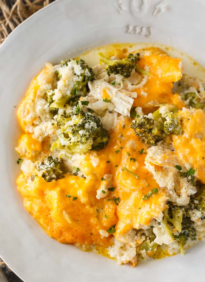 Simply Stacie Chicken Divan Pinterest Pin with cheesy chicken and broccoli with cauliflower rice in white bowl