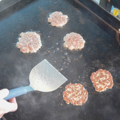Sausage patties flipped and cooking on the 2nd side on the blackstone griddle
