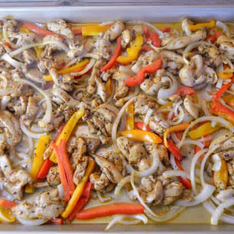 chicken partially cooked and tossed before more cooking in sheet pan