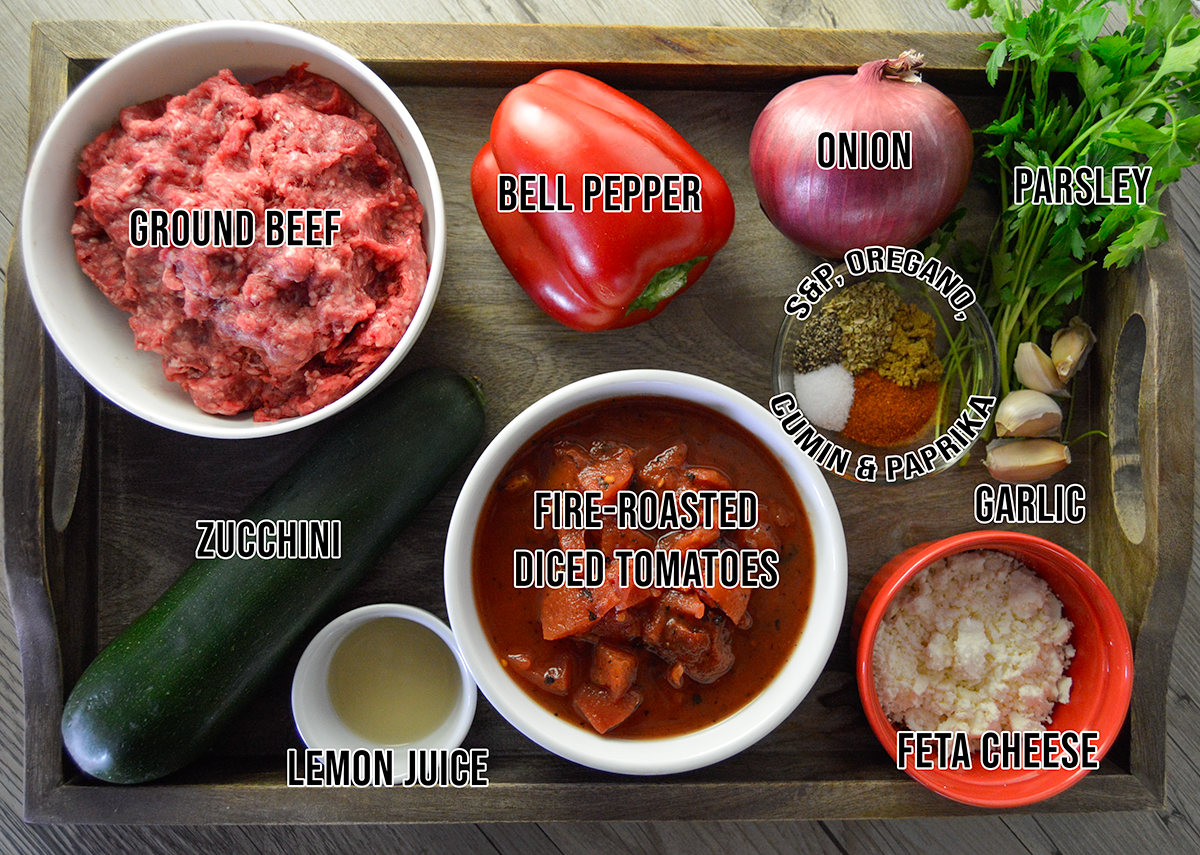 Ingredients for Mediterranean ground beef dish shown on wooden tray